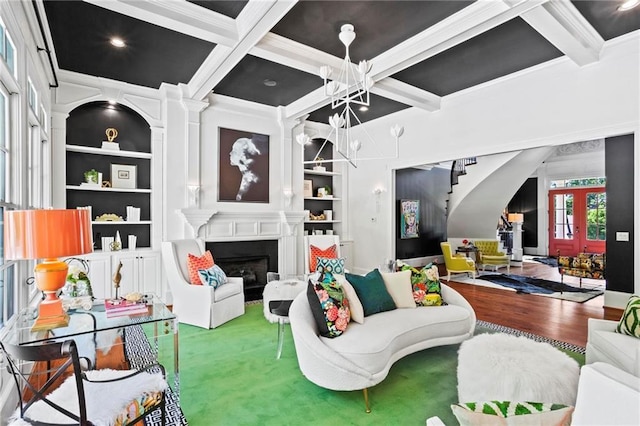 living room with beamed ceiling, coffered ceiling, a fireplace, and built in shelves