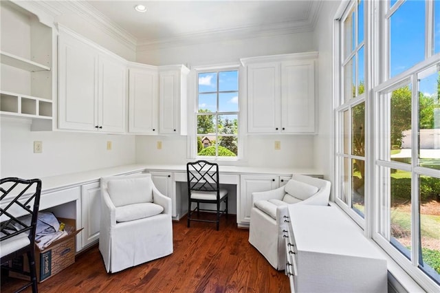 living area featuring crown molding, dark hardwood / wood-style floors, and built in desk