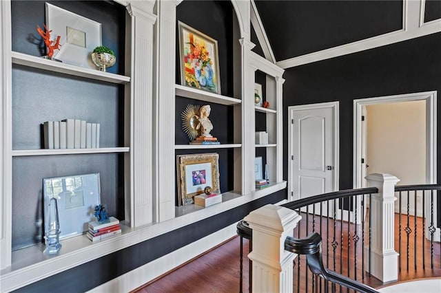 corridor featuring wood-type flooring, built in features, and crown molding