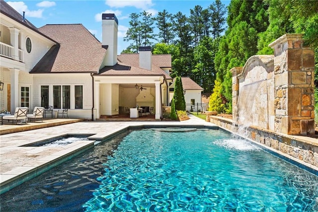 view of swimming pool featuring pool water feature, a patio, and ceiling fan