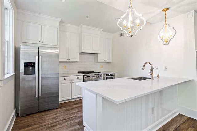 kitchen featuring sink, hanging light fixtures, appliances with stainless steel finishes, dark hardwood / wood-style floors, and white cabinets