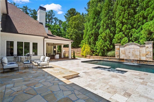 view of pool with pool water feature, ceiling fan, outdoor lounge area, and a patio