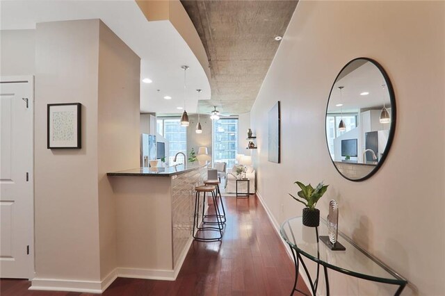 855 Peachtree St NE Unit 1311, Atlanta, GA 30308 - kitchen featuring stainless steel appliances, dark wood-style flooring, dark stone countertops, a kitchen bar, and white cabinets