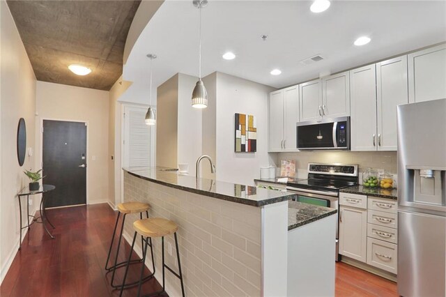 855 Peachtree St NE Unit 1311, Atlanta, GA 30308 - kitchen featuring stainless steel appliances, a sink, white cabinetry, dark wood-type flooring, and dark stone countertops
