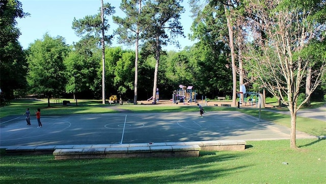 view of sport court with a playground and a lawn