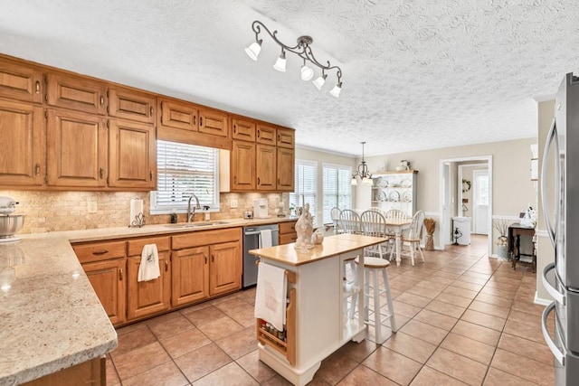 3574 Timberloch Trl, Snellville, GA 30039 - kitchen with a sink, stainless steel appliances, decorative backsplash, light tile patterned flooring, and pendant lighting