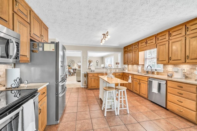 3574 Timberloch Trl, Snellville, GA 30039 - kitchen featuring appliances with stainless steel finishes, a sink, decorative backsplash, and light countertops