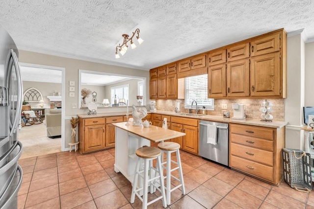 3574 Timberloch Trl, Snellville, GA 30039 - kitchen featuring appliances with stainless steel finishes, a sink, light countertops, a breakfast bar area, and crown molding