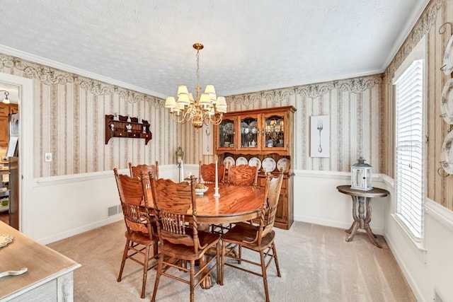 3574 Timberloch Trl, Snellville, GA 30039 - dining space with a chandelier, a wainscoted wall, wallpapered walls, a textured ceiling, and light carpet