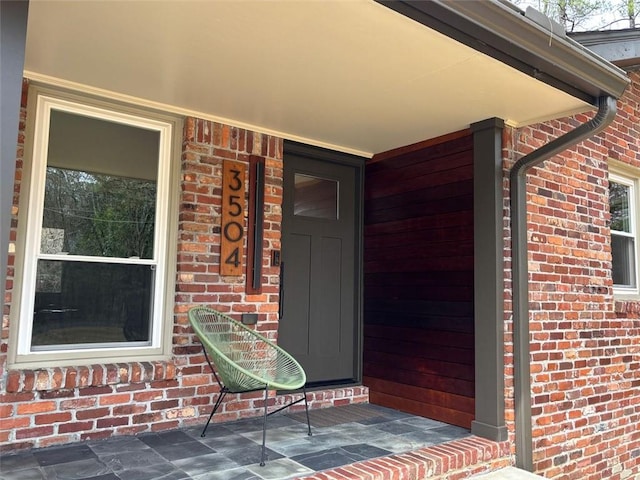 view of exterior entry with brick siding