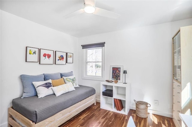 bedroom with a ceiling fan, wood finished floors, and baseboards