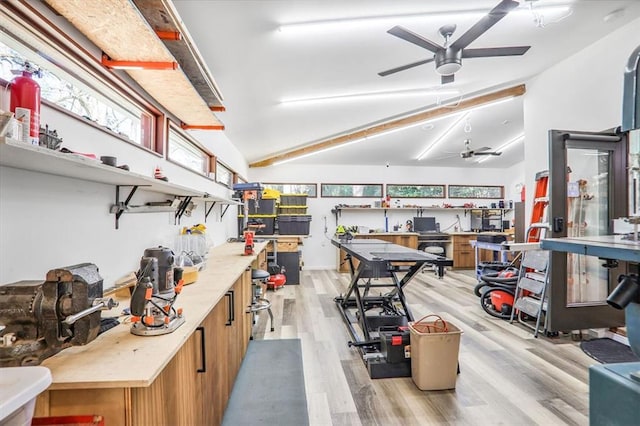 interior space featuring ceiling fan, light countertops, lofted ceiling, light wood-style flooring, and brown cabinets