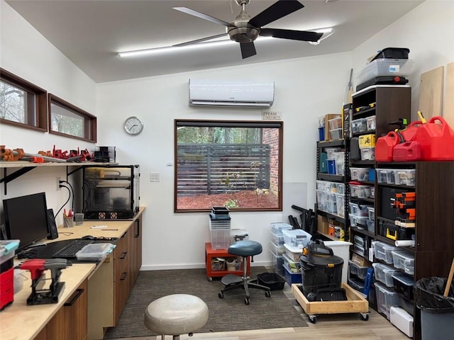 home office with baseboards, an AC wall unit, wood finished floors, and a ceiling fan