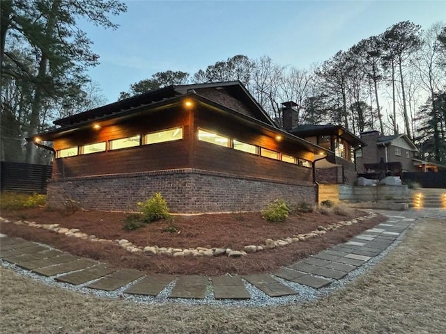 view of home's exterior featuring brick siding and a chimney