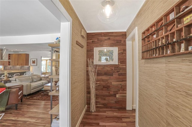 hallway with wood finished floors and wood walls