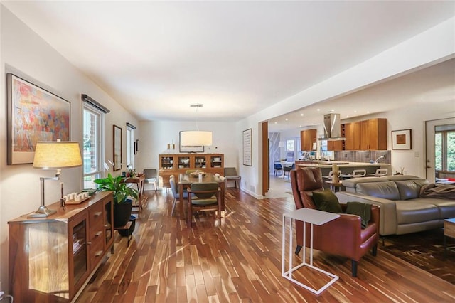 living area with dark wood-type flooring and baseboards