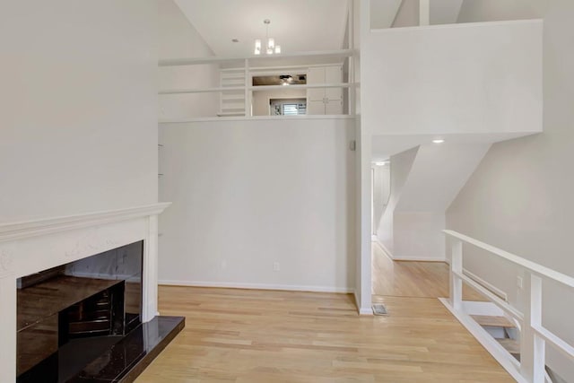 living area with a fireplace, baseboards, vaulted ceiling, and wood finished floors