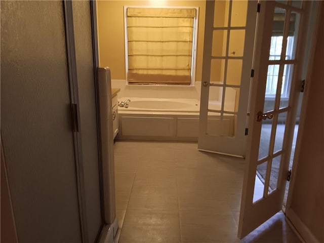 corridor featuring light tile patterned flooring and french doors