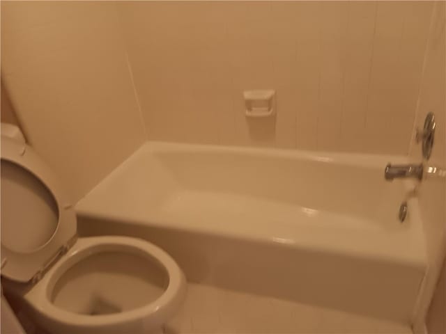 bathroom with tiled shower / bath and toilet