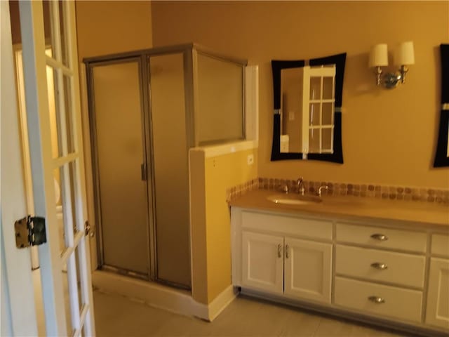 bathroom with a shower with door and vanity