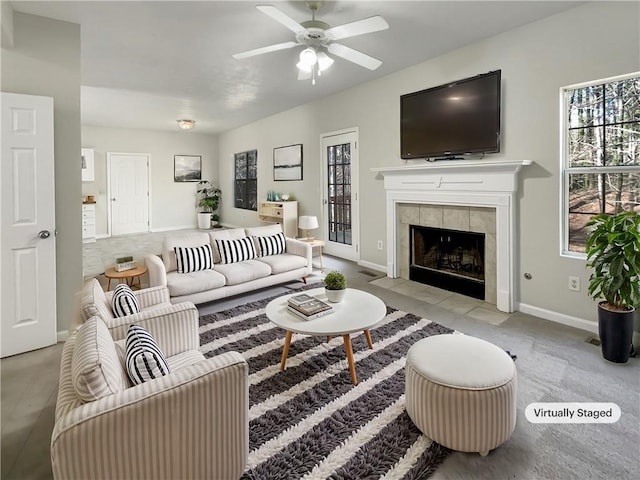 living room with a fireplace, baseboards, and a ceiling fan