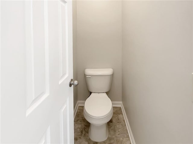 bathroom with baseboards and toilet