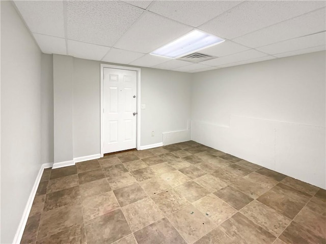 spare room with a drop ceiling, visible vents, and baseboards