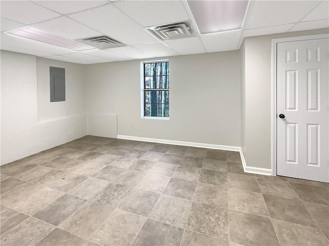 empty room with electric panel, a paneled ceiling, visible vents, and baseboards