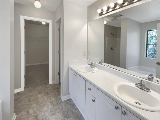 full bathroom featuring a garden tub, a walk in closet, walk in shower, and a sink