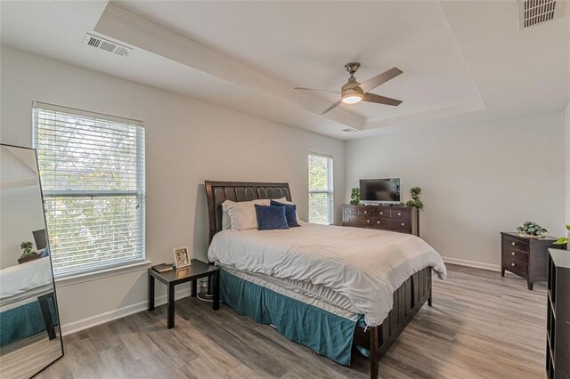 bedroom featuring multiple windows, ceiling fan, and light hardwood / wood-style flooring