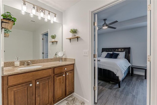 bathroom with hardwood / wood-style floors, vanity, and ceiling fan