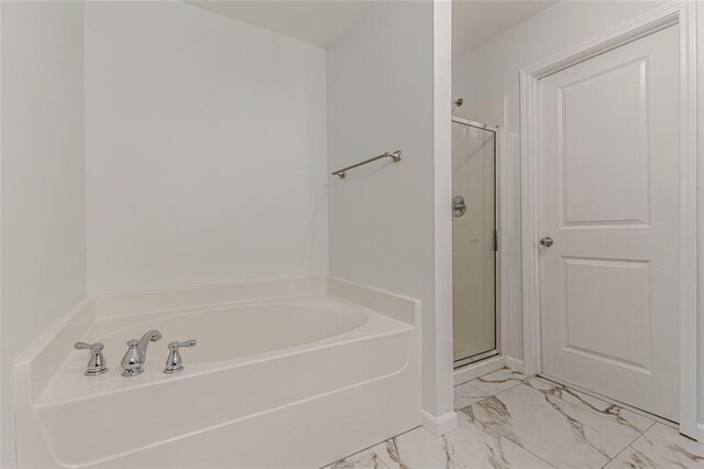 bathroom featuring shower with separate bathtub