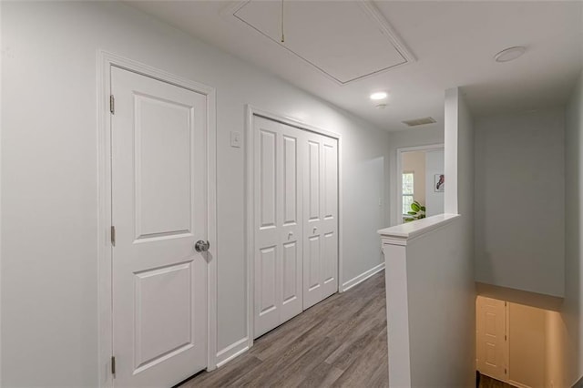 corridor with hardwood / wood-style flooring