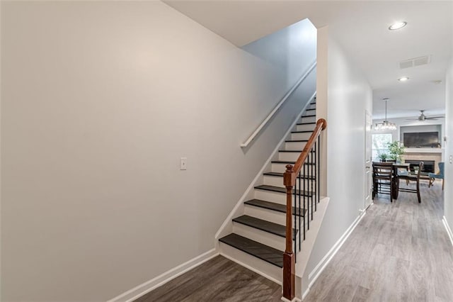 stairway featuring hardwood / wood-style flooring and ceiling fan