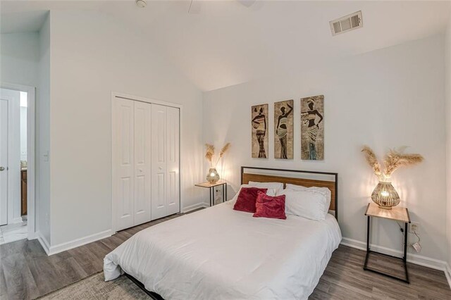 bedroom with hardwood / wood-style floors, ceiling fan, a closet, and lofted ceiling