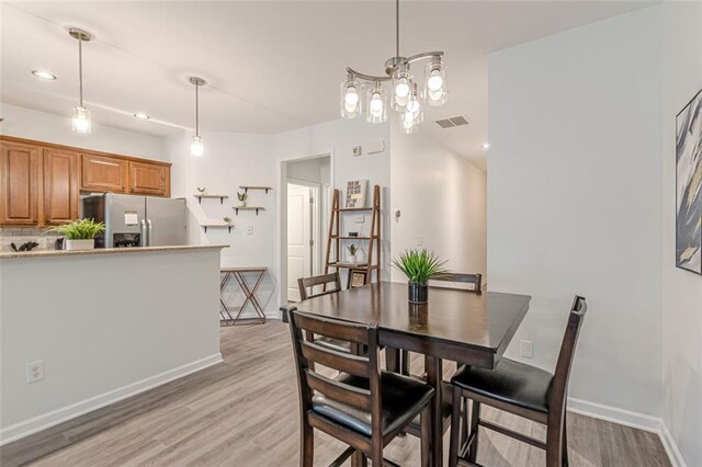 dining area featuring a chandelier and light hardwood / wood-style flooring