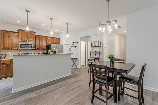 dining room featuring light hardwood / wood-style flooring and a notable chandelier