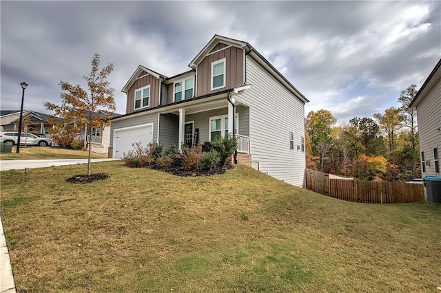 view of front of home featuring a garage, a front yard, and covered porch