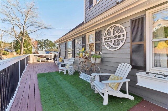 wooden terrace featuring a yard