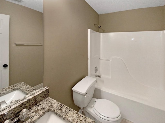 full bath featuring vanity, toilet, washtub / shower combination, and a textured ceiling