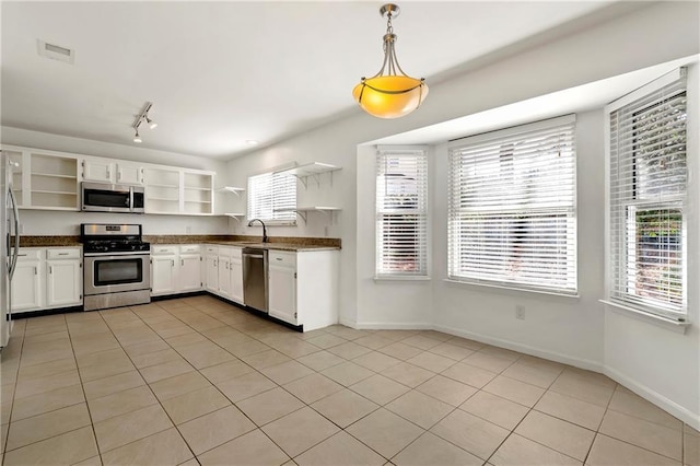 kitchen with light tile patterned floors, a sink, appliances with stainless steel finishes, open shelves, and dark countertops