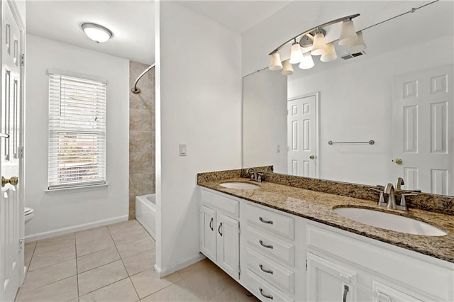 bathroom with double vanity, toilet, a sink, and tile patterned floors