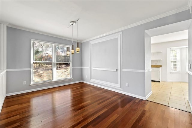 unfurnished dining area featuring ornamental molding, wood finished floors, and a wealth of natural light