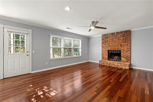 unfurnished living room featuring a healthy amount of sunlight, wood finished floors, visible vents, and crown molding