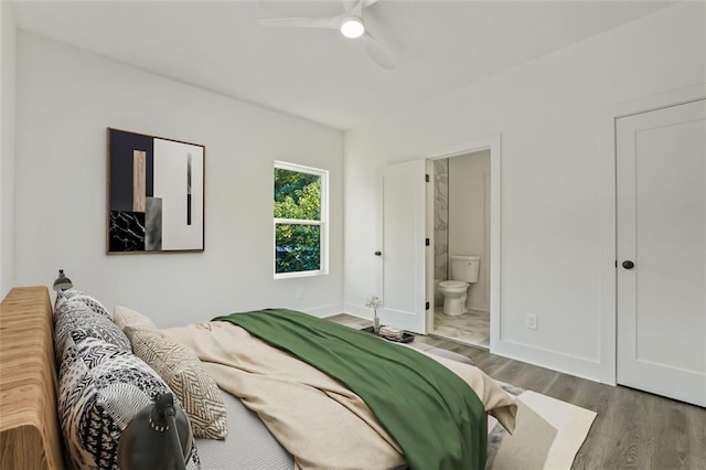 bedroom with ceiling fan, ensuite bathroom, and dark hardwood / wood-style floors