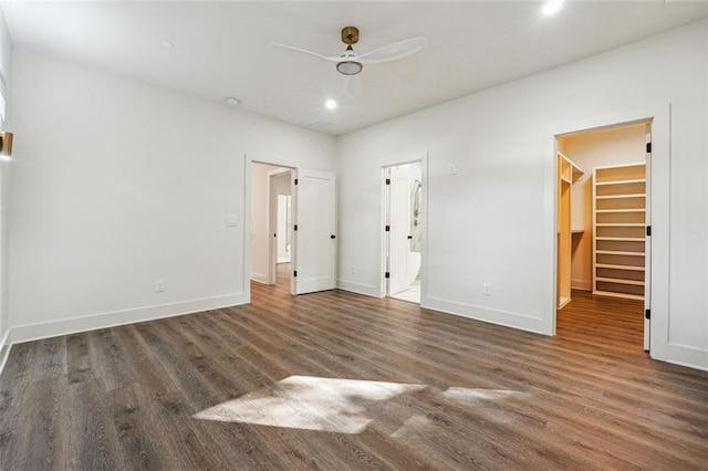 unfurnished bedroom with ceiling fan, connected bathroom, dark hardwood / wood-style flooring, a walk in closet, and a closet