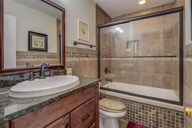 500 Nicole Ct SE, Conyers, GA 30094 - full bathroom with vanity, tile walls, shower / bath combination with glass door, and toilet
