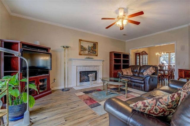 500 Nicole Ct SE, Conyers, GA 30094 - living room featuring crown molding, ceiling fan with notable chandelier, a premium fireplace, and light wood-type flooring