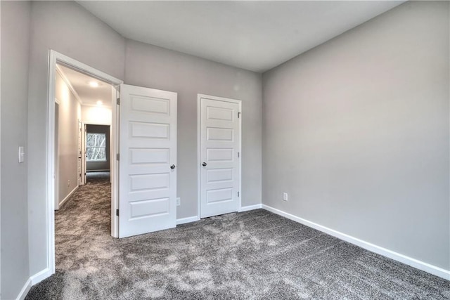 unfurnished bedroom with dark carpet and a closet