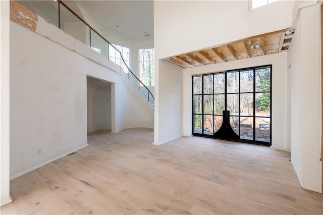 interior space featuring light hardwood / wood-style floors, a towering ceiling, and french doors